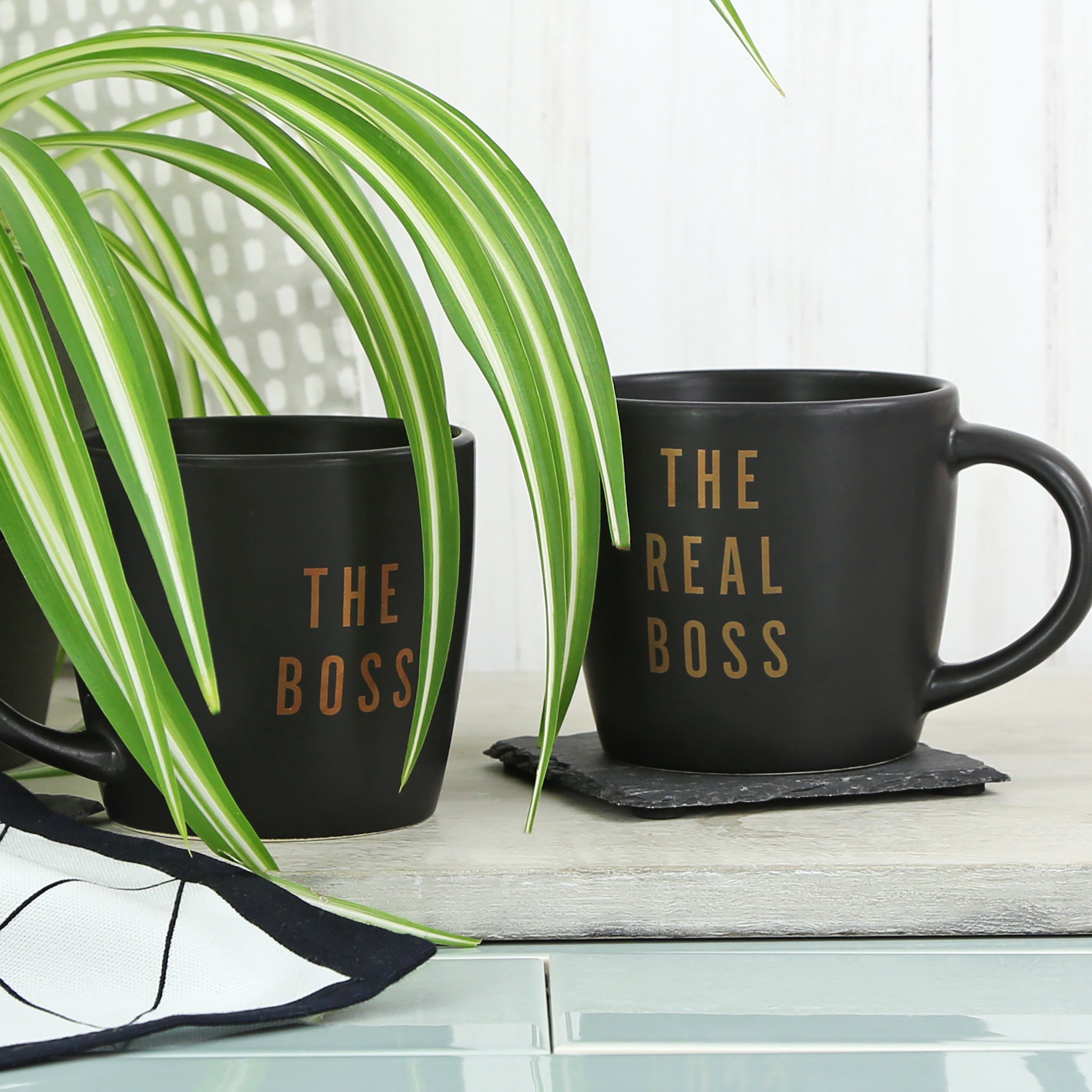 Two black ceramic mugs with boss slogan foil decals