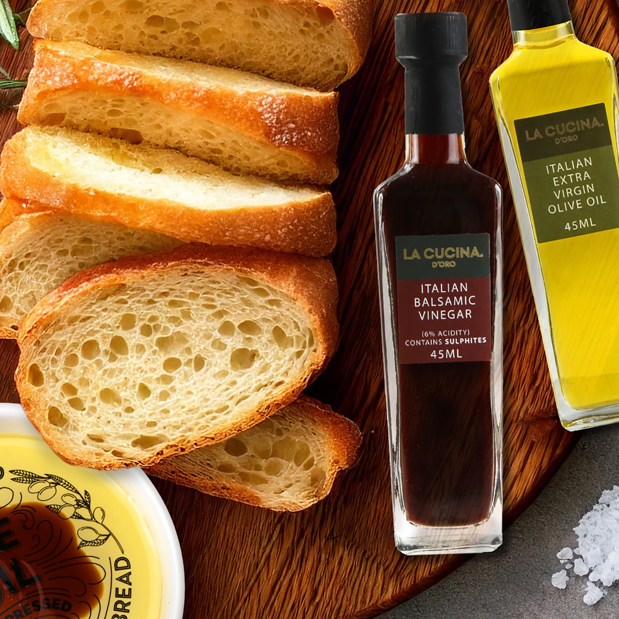 Bottles of olive oil and balsamic vinegar with a dipping dish for bread