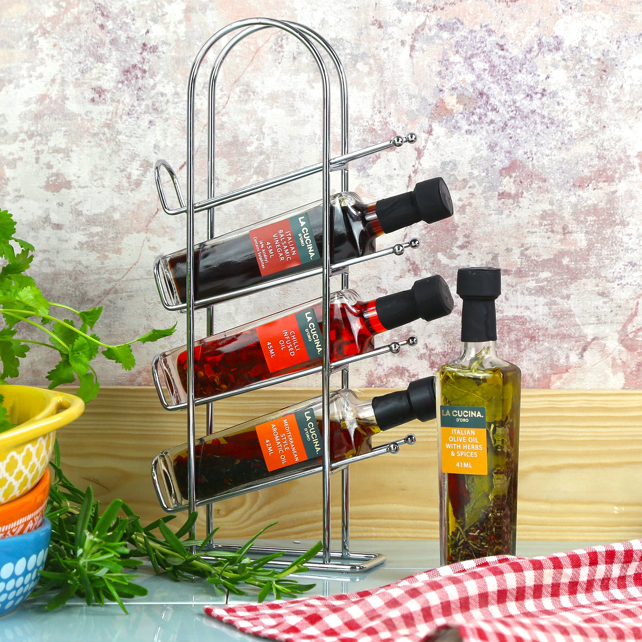 4 bottle of different flavoured cooking oils and balsamic vinegar presented on a metal rack