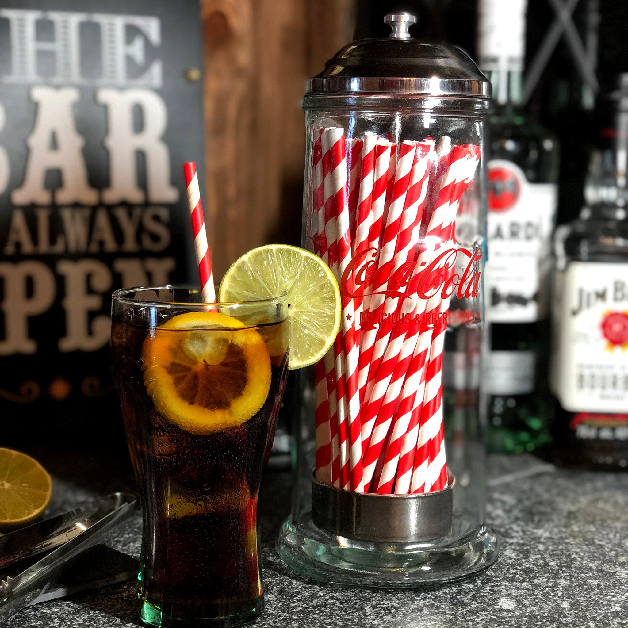 Coca-Cola branded glass straw dispenser with paper straws inside